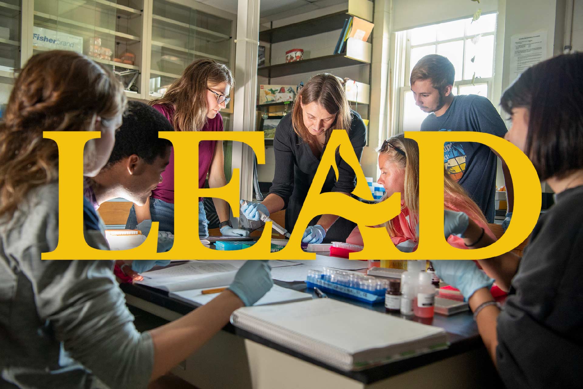 A group of people in a science lab work together around a table, collaborating on curriculum development, with the word 铅 in large yellow letters over the image.